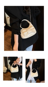 Detail of cream glossy patent leather bucket bag with bow accent and chain strap