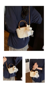 Detail of woven straw bucket bag featuring brown leather handles and plush animal charm