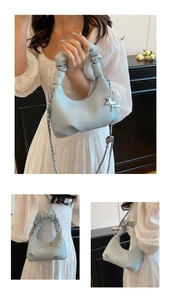 Detail of light blue crescent bag featuring lychee grain leather and silver chain strap