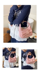 Detailed view of a glossy pink bow bucket bag featuring a sleek metallic chain strap
