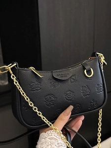Chic black embossed leather crescent shoulder bag with golden chain and cartoon motif