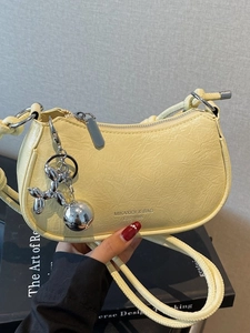 Minimalist lemon yellow pleated underarm bag with silver balloon dog pendant and strap