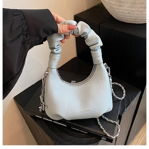 Gros plan du sac à main plissé bleu clair avec texture grainée et fermeture éclair argentée