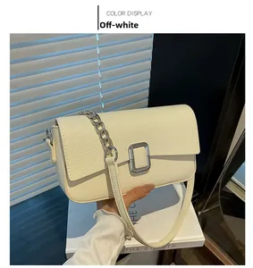 Detail view of off-white textured leather bag with silver buckle and chain strap