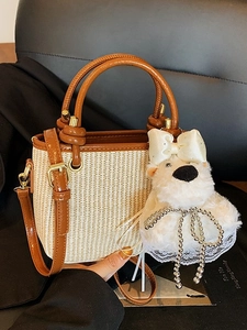 Stylish beige woven straw handbag with brown leather straps and cute plush bear charm