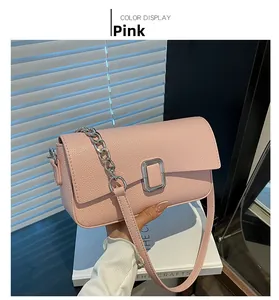 Detailed close-up of pink lychee grain leather crossbody bag with silver buckle and chain
