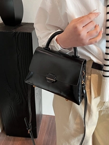 Minimalist black glossy large tote bag with top handle and gold clasp for women