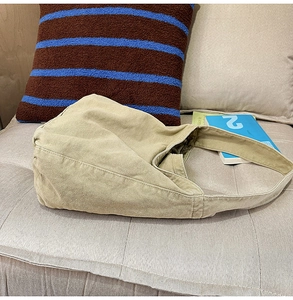 Macro detail of the khaki canvas tote bag showing thick texture and durable wide strap