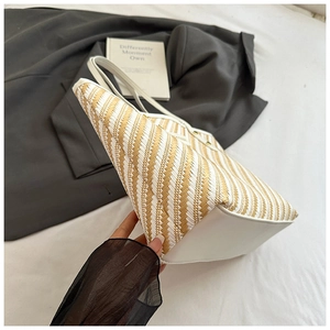 Detail of herringbone woven tote bag with white leather straps and spacious interior