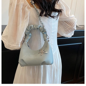 Detail of light blue pleated cloud bag with textured leather and chain strap
