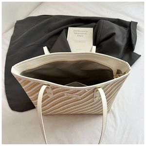 Detail view of large capacity striped straw tote bag with inner pocket and zipper