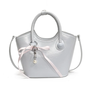 Fashionable light blue bucket bag with round handles and pink ribbon decoration