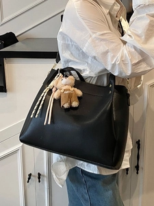 Large black minimalist tote bag with bear charm and long strap for women's daily commute