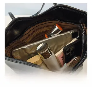 Top view of large black tote bag with striped lining showing spacious inner storage