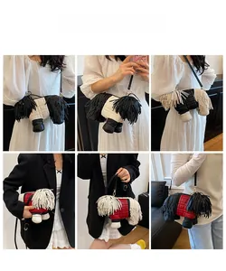 Detail view of dog-shaped crossbody bag with long fringe and quilted leather accents