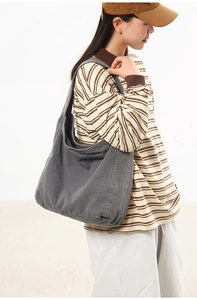 Detail of soft charcoal grey canvas crossbody bag showing texture and wide strap