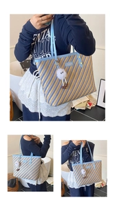 Detail of striped woven tote bag with light blue leather straps and plush charm