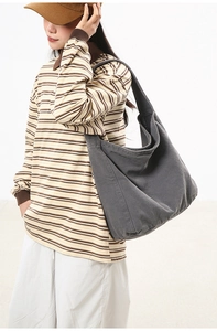 Detail shot of the thick grey washed canvas fabric texture and crossbody strap on tote bag