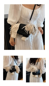 Detailed view of creative sheepdog crossbody bag with black quilting and white fringe