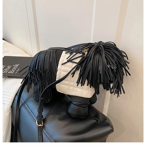 Detail of creative dog-shaped crossbody bag with black leather fringes and quilted pattern