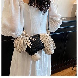 Detail of creative dog-shaped crossbody bag featuring black quilted leather and long tassels