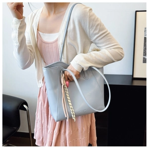 Detail of light blue PU tote bag with long handles and fashion brand lettering logo