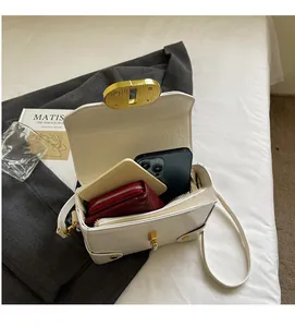 Vue de dessus du sac en cuir plissé blanc avec fermoir doré montrant l'intérieur spacieux