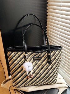 Large striped woven tote bag with black leather handles and cute monster charm