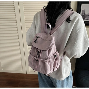 Detail view of the lavender nylon backpack showing drawstring closure and flap buckle design
