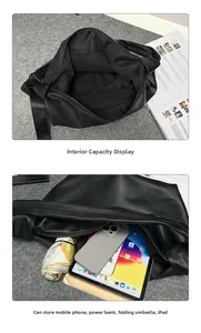 Detail of black leather tote bag showing spacious interior with iPad and folding umbrella
