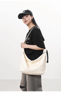 Side view of large cream hobo tote bag shown on model for daily commute use