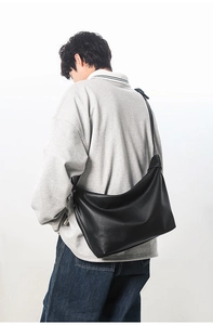 Model view showing the back profile of a large black minimalist crossbody tote bag