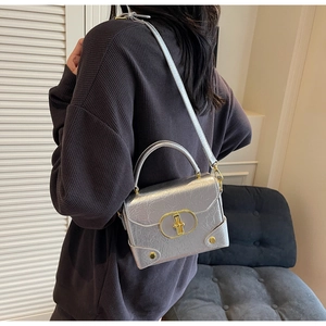 Détail d'un sac bandoulière argenté texturé avec fini métallique et fermoir doré