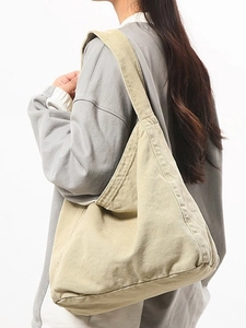 Beige washed canvas hobo bag with wide shoulder strap shown on model for daily casual wear