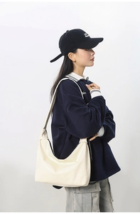 Detailed side view of large cream white hobo bag on model for casual styling