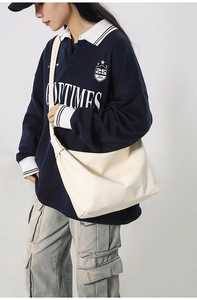 Detail of cream white large capacity hobo bag showing soft leather texture and wide strap