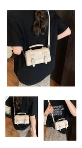 Détail du sac à main beige rectangulaire avec gaufrage oreilles de chat et boucles