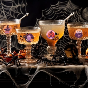 Close-up of Halloween character stickers applied to party glassware in a spooky setting
