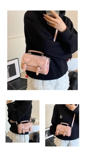 Vue détaillée du sac à main en cuir verni rose avec nœuds et boucles métalliques décoratives