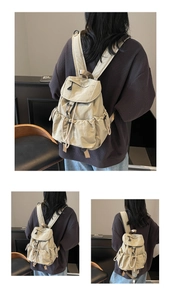 Detail of off-white nylon backpack with drawstring closure and adjustable straps