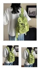 Detail of light green canvas backpack with drawstring closure and adjustable straps