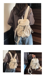 Detailed view of cream nylon drawstring backpack with functional pockets and utility hooks