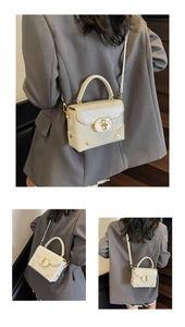 Vue détaillée du sac bandoulière crème texturé avec boucle métallique dorée chic
