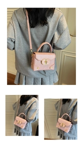 Vue détaillée du sac bandoulière en cuir rose avec clous dorés et bandoulière réglable