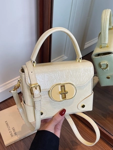Sac bandoulière chic en cuir verni blanc crème avec fermoir rotatif doré élégant
