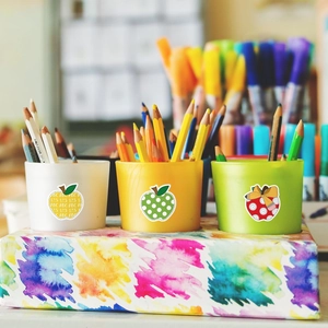 Detail view of colorful Halloween apple stickers on stationery organizers with pencils