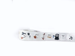 Close-up of Halloween ghost stickers roll featuring cute cartoon pumpkin and witch hats