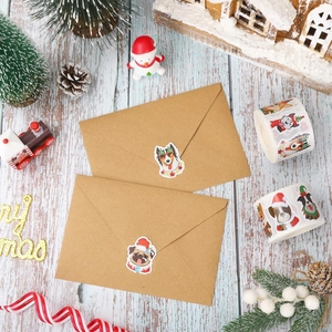 Christmas dog stickers on kraft envelope with holiday decor on a blue wood background