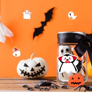 Detail of Halloween ghost and vampire stickers on white pumpkins and glass jars