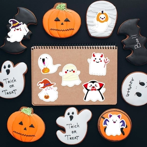 Close-up of cute cartoon ghost and mummy Halloween stickers on a kraft paper notebook